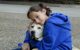 Girl snuggling with dog