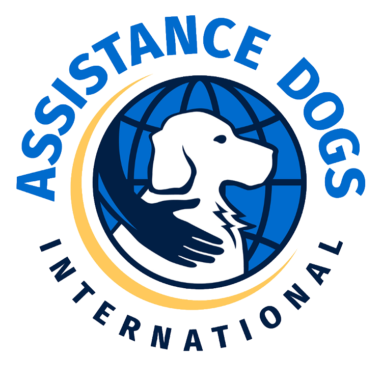 Logo with a white dog silhouette in front of a blue globe, encircled by a dark hand and yellow crescent. ASSISTANCE DOGS INTERNATIONAL is written around the image in blue and yellow text.